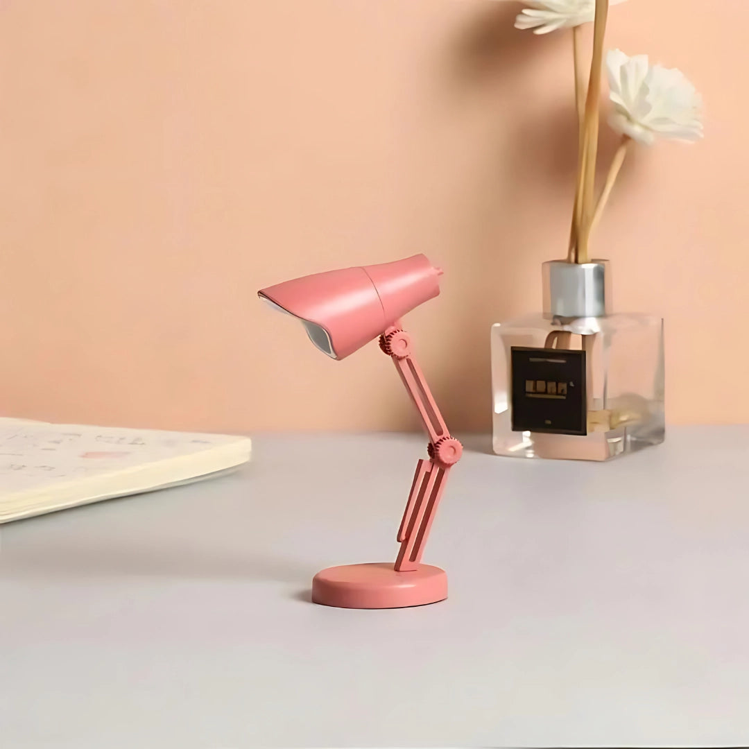 A stylish Coral Mini LED Adjustable Desk Lamp in a Pink Rose finish, featuring a sleek design ideal for enhancing office or home lighting decor.